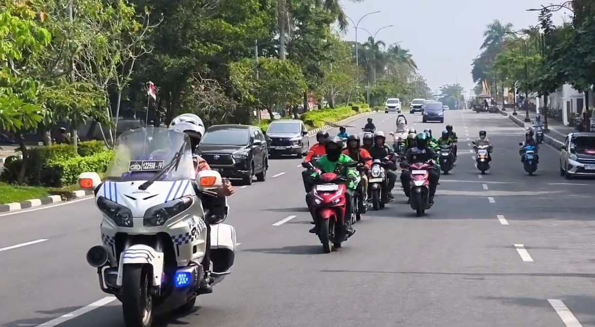 Ditlantas Polda Riau Bersama Ojol Bagikan Sembako dan Helm SNI